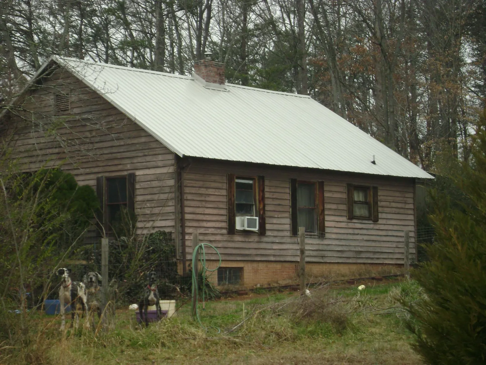 White metal roof on an old wood sided farmhouse, from a Metal Roof Installation job in Marietta